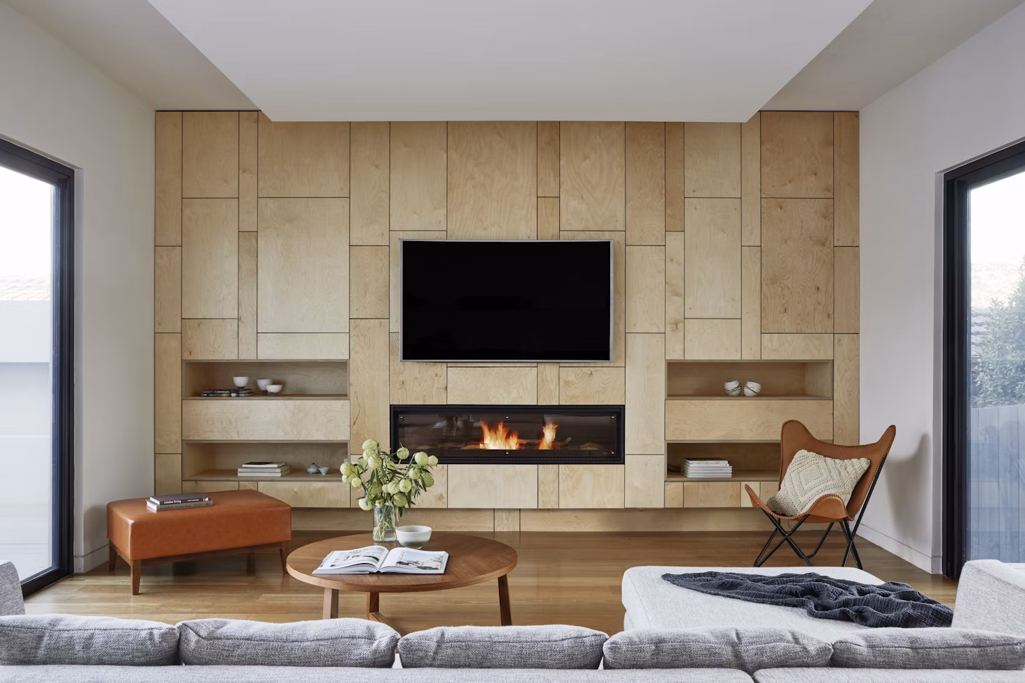 a TV mounted on a wood accent wall