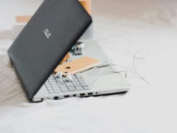 an ASUS laptop on a white surface with an iPhone on it.