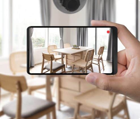Hand holding a wireless device to monitor home surveillance footage