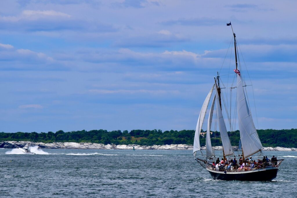 Sailboat with a lot of people in it under a blue sky near Cranston, Rhode Island.