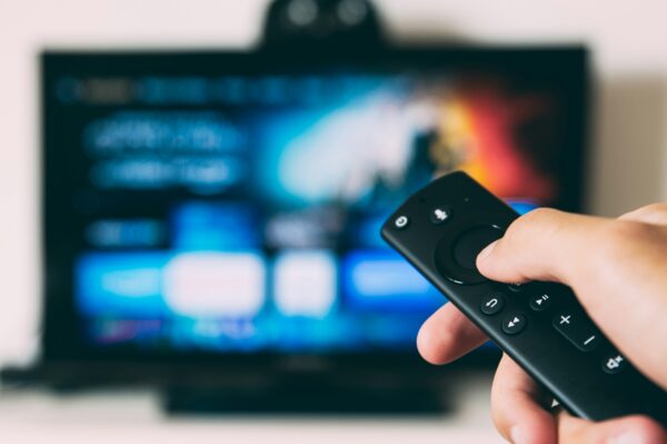 someone pointing a TV remote at their TV.