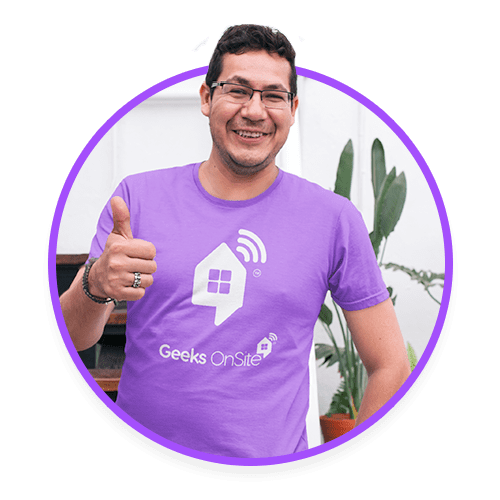 Male Geeks on Site employee in a purple shirt giving a thumbs-up.