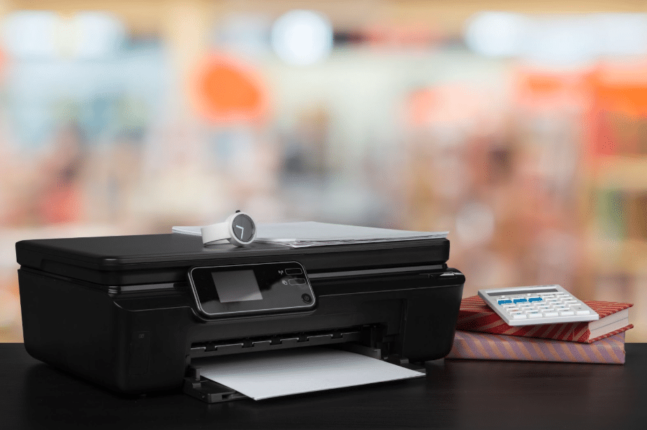 printer next to stack of books