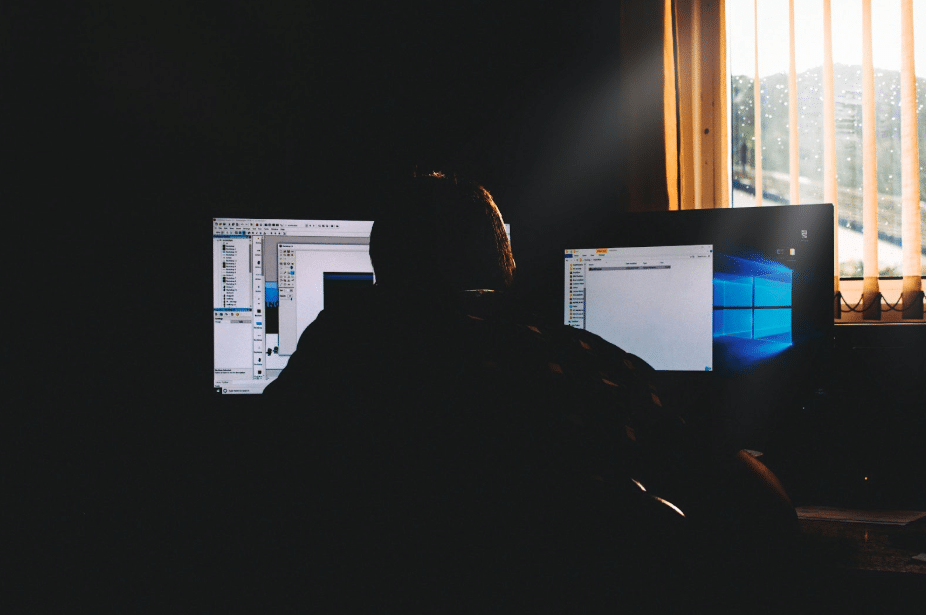silhouette of man in front of computers