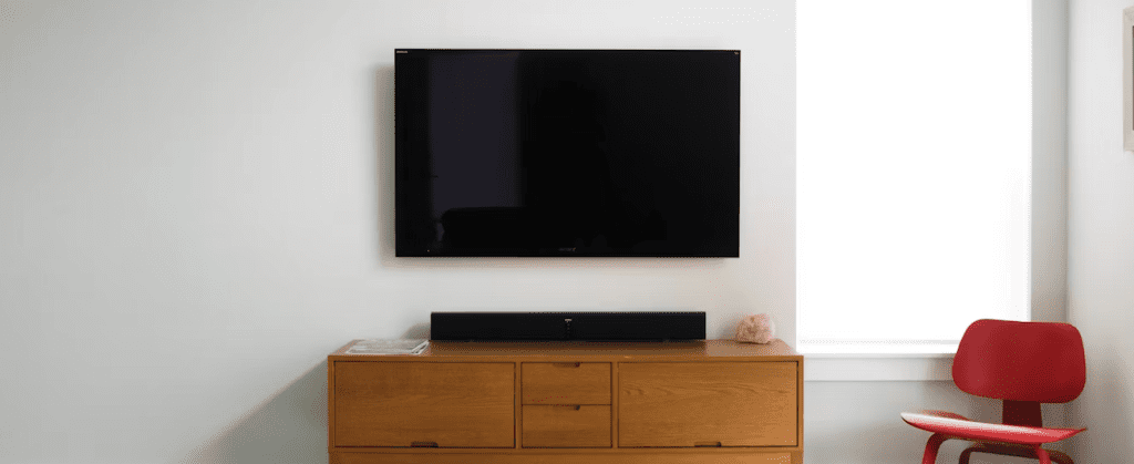 a TV mounted above a wood console table