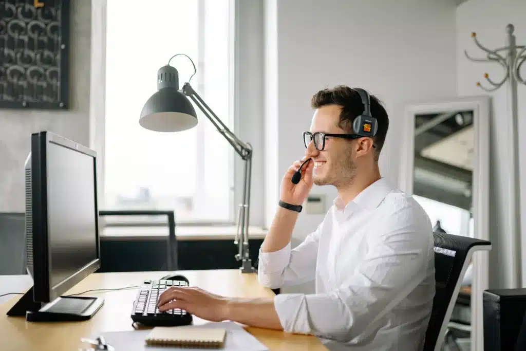 a man with a headset using a desktop computer.